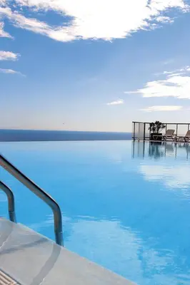 a view of a pool of blue water with chairs at Appt 5 personnes vue mer piscine Costa Plana Cap d'Ail Monaco in Cap d'Ail
