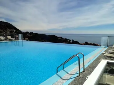 a large blue swimming pool with a view of the ocean at Appt 5 personnes vue mer piscine Costa Plana Cap d'Ail Monaco in Cap d'Ail