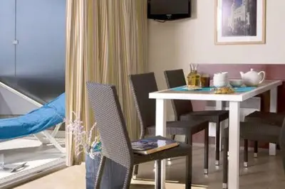 a dining room with a white table and chairs at Appt 5 personnes vue mer piscine Costa Plana Cap d'Ail Monaco in Cap d'Ail