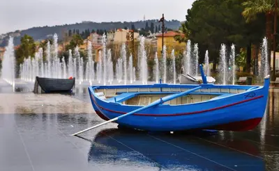 a blue boat in front of a fountain at 