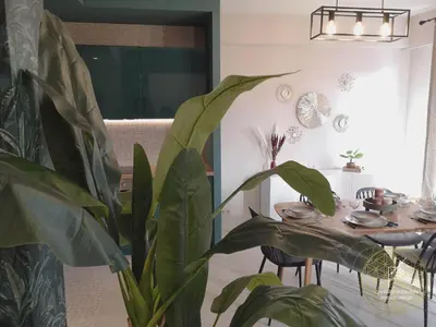 a dining room with a table and a plant at Appartement Carré d'Or Vue sur Mer in Nice