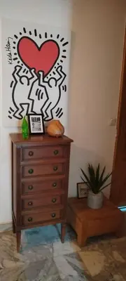 a dresser with a painting of a heart on the wall at Chez Brigitte Guesthouse in Nice