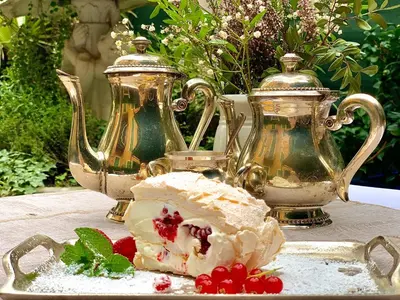 a piece of cake on a table with two tea pots at Hôtel restaurant Oasis in Nice