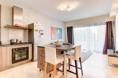 a kitchen and living room with a couch and a refrigerator at La Lanterne Plage in Nice