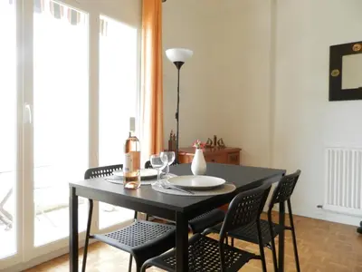 a dining room with a black table and chairs at Les Pins . 2 p calme et terrasse in Nice