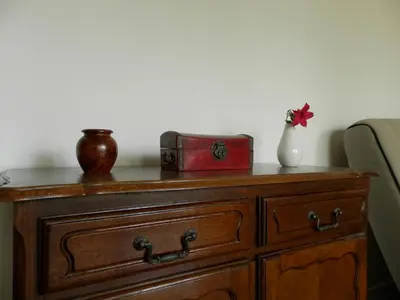 a wooden dresser with a red box and a vase on it at Les Pins . 2 p calme et terrasse in Nice