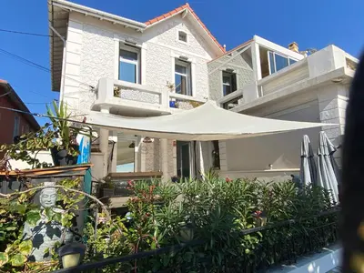 a white house with a white umbrella in front of it at O Phare du Cros in Cagnes-sur-Mer