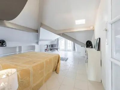 a bedroom with a bed in a white room at Les Citronniers in Villefranche-sur-Mer