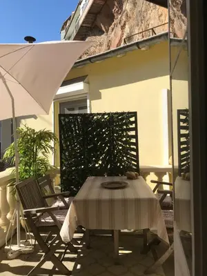 a table and chairs and an umbrella on a patio at Les Citronniers in Villefranche-sur-Mer