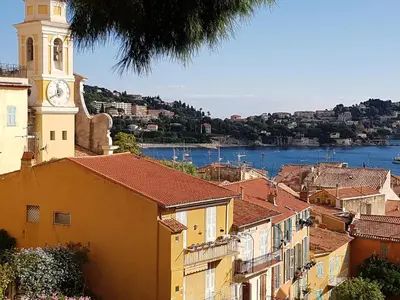a view of a city with a clock tower at Les Citronniers in Villefranche-sur-Mer