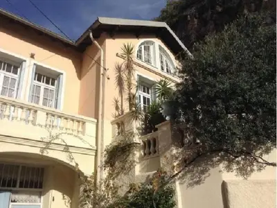 a house with palm trees on the side of it at Les Citronniers in Villefranche-sur-Mer