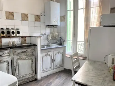 a kitchen with a stove and a refrigerator and a table at Nice Center Room in Nice