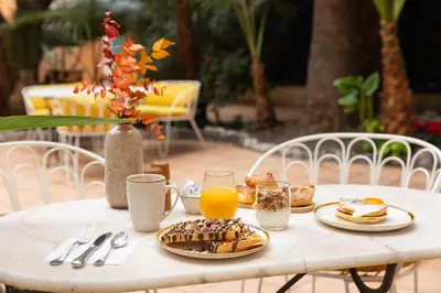 a table with a breakfast of pancakes and orange juice at Maison Durante in Nice