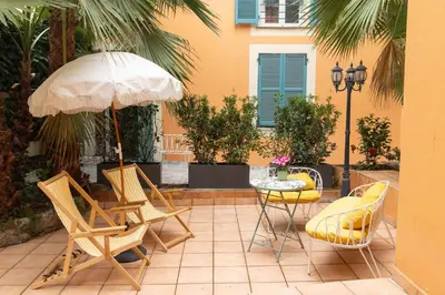 a patio with a table and chairs and an umbrella at Maison Durante in Nice