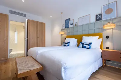 a bedroom with a large white bed with blue pillows at Maison Durante in Nice
