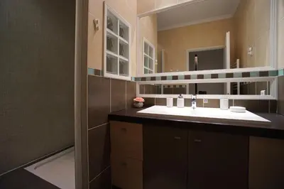 a kitchen with dark brown cabinets and a table and chairs at Apartment with parking in Nice near the harbor in Nice