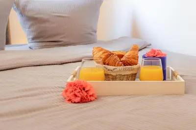 a tray with a basket of bread and two glasses of orange juice at Boutique apartment LA LAVANDE free parking CENTER Nice in Nice
