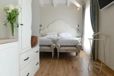 a bedroom with a bed and a vase of flowers at Hôtel Eze Hermitage in Èze