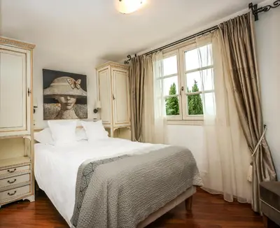 a bedroom with a large white bed and a window at Hôtel Eze Hermitage in Èze