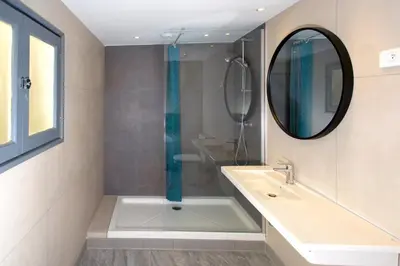 a bathroom with a tub and a sink and a mirror at Villa Saint Exupery Beach Hostel in Nice