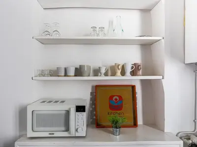 a kitchen with a microwave and a picture on a counter at Apartment Hérold-1 by Interhome in Nice
