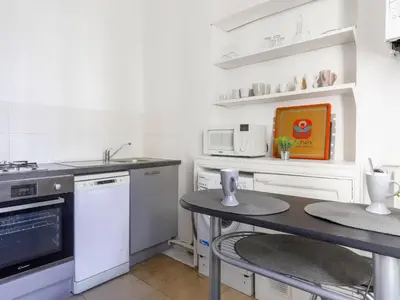 a kitchen with a sink and a table with two tables at Apartment Hérold-1 by Interhome in Nice