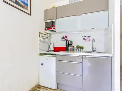a small kitchen with white cabinets and a refrigerator at Studio Ciel de Fabron by Interhome in Nice