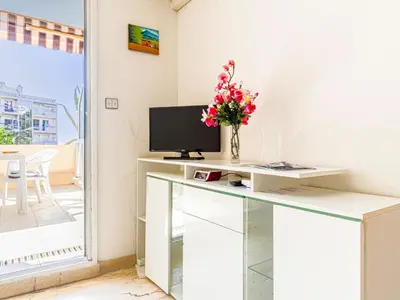 a white desk with a television and flowers on it at Studio Ciel de Fabron by Interhome in Nice