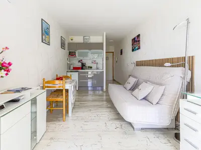 a living room with a white couch and a kitchen at Studio Ciel de Fabron by Interhome in Nice