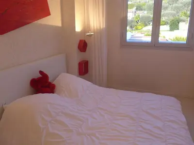 a red teddy bear sitting on top of a bed at Apartment Les Balcons d'Eze-1 by Interhome in Èze