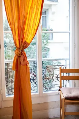 a window with an orange curtain in front of it at Nice Riviera Sweet Home Chambres d'hotes in Nice