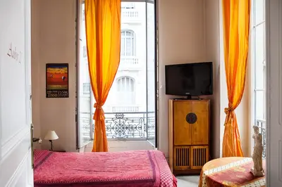 a room with two beds and a tv and a window at Nice Riviera Sweet Home Chambres d'hotes in Nice