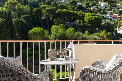 a table and two chairs on a balcony with a view at Le Corot in Beaulieu-sur-Mer