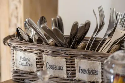 a wicker basket with spoons and forks and knives at Le Corot in Beaulieu-sur-Mer