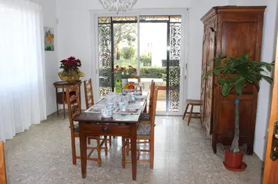 a dining room with a table with glasses on it at Villa Calliste in Saint-Laurent-du-Var