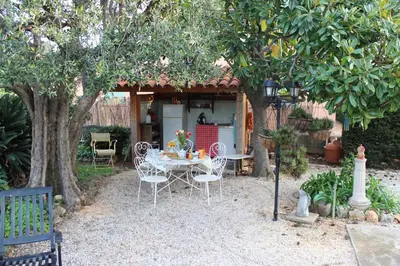 a patio with a table and chairs under a tree at Villa Calliste in Saint-Laurent-du-Var