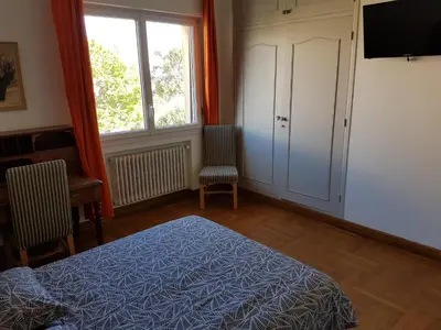 a bedroom with a bed and a window and a tv at Villa Calliste in Saint-Laurent-du-Var
