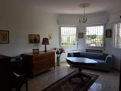 a living room with a blue couch and a table at Villa Calliste in Saint-Laurent-du-Var