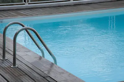 a swimming pool with a hand rail next to the water at Studio With Swimming Pool 80 meters near the beach in Nice