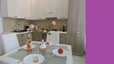 a white kitchen with a door and a table and chairs at NICE FRANCE Apartment 2 rooms max 4 persons in Nice