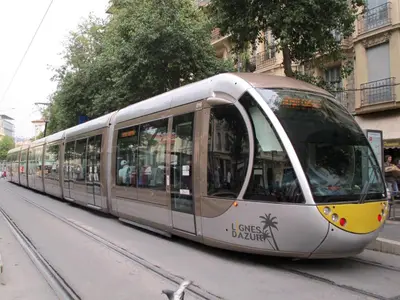a silver tram on a city street at Appartement in Nice