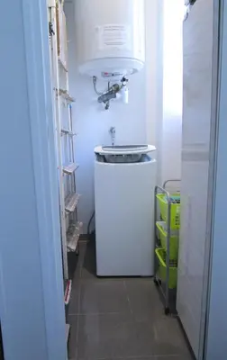 a small white refrigerator in a hallway with a light at Appartement in Nice