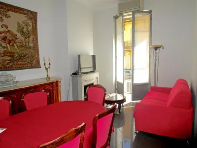a living room with a red table and chairs at Appartement in Nice