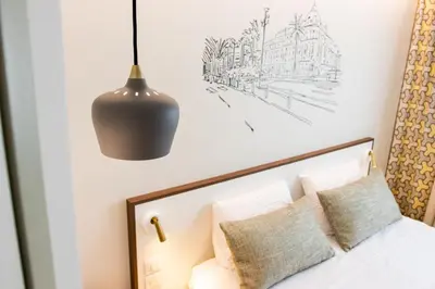 a bedroom with a bed and a pendant light at Hotel du Pin Nice Port in Nice