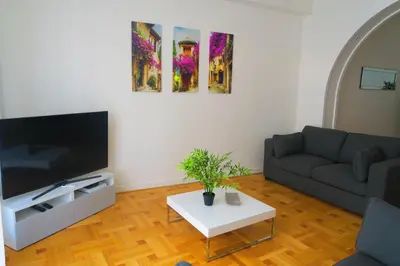 a living room with a couch and a tv at Carré d’Or Appt 4 Pièces moderne et spacieux in Nice