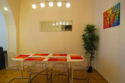 a table in a room with chairs and a painting at Carré d’Or Appt 4 Pièces moderne et spacieux in Nice
