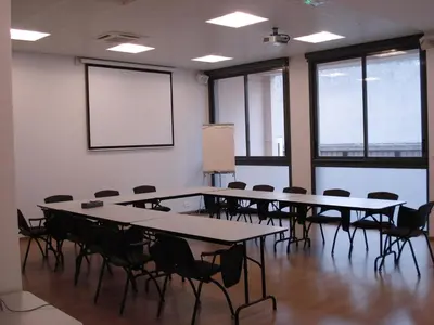 a conference room with tables and chairs and a whiteboard at Esatitude Hotel in Nice