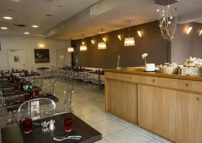a restaurant with tables and chairs and a bar at Esatitude Hotel in Nice