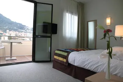 a hotel room with a bed and a balcony at Esatitude Hotel in Nice