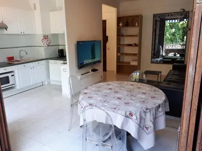a kitchen and dining room with a table and a television at Appart bas Fabron in Nice